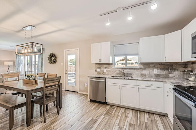 338 Liberty St, Hutto, TX 78634 - kitchen featuring white cabinetry, stainless steel appliances, decorative backsplash, and a sink