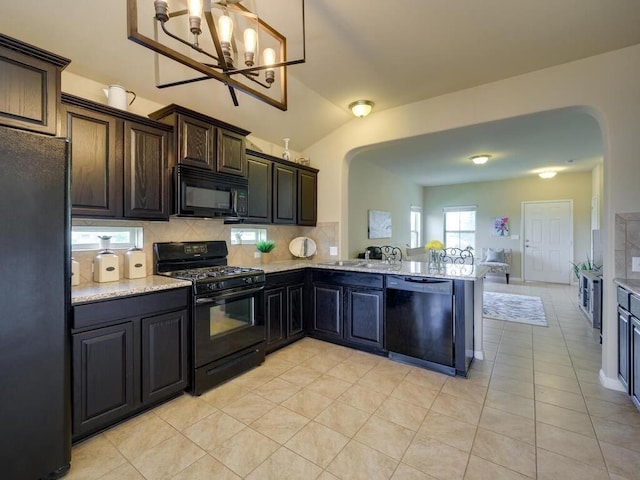 kitchen featuring an inviting chandelier, backsplash, arched walkways, and black appliances