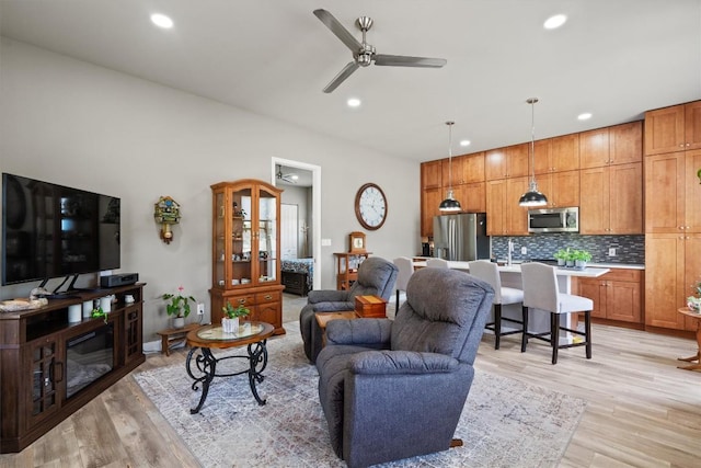 living room with ceiling fan, recessed lighting, and light wood-style floors