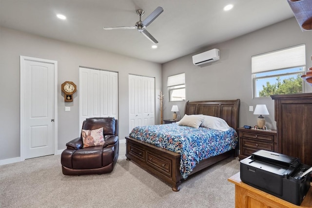 bedroom with two closets, a wall mounted air conditioner, light colored carpet, and recessed lighting
