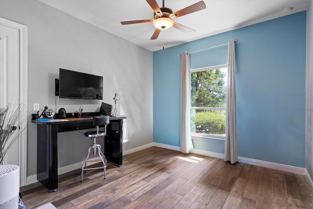office space with baseboards, ceiling fan, and wood finished floors