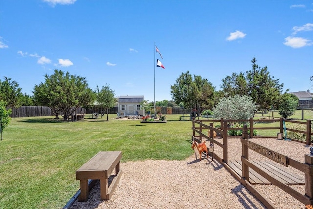 view of property's community featuring a yard and fence