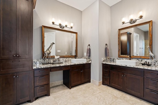 bathroom featuring tile patterned flooring, two vanities, and a sink
