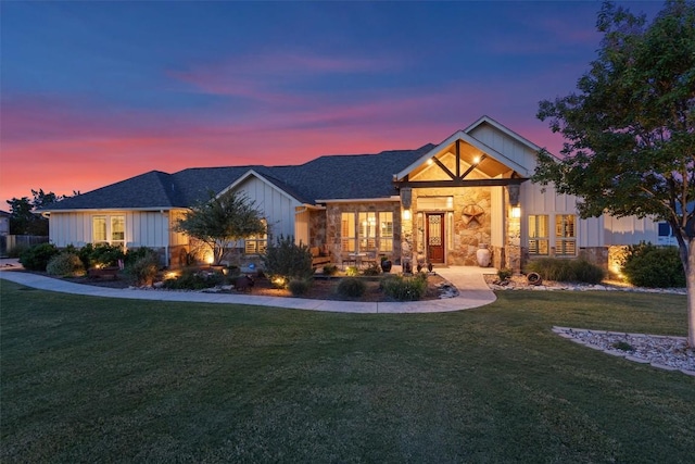 ranch-style home featuring stone siding, board and batten siding, and a lawn