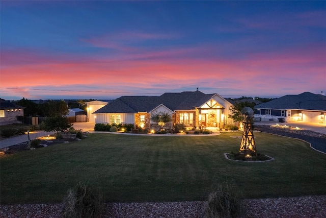 view of front of property with an outdoor fire pit and a lawn