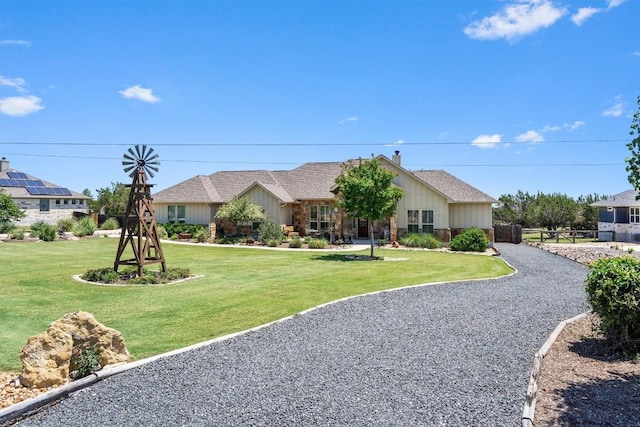 single story home featuring board and batten siding, fence, and a front yard