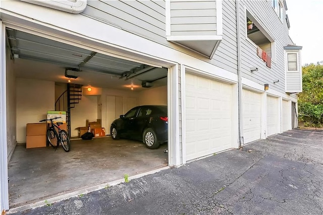 garage with aphalt driveway and a garage door opener