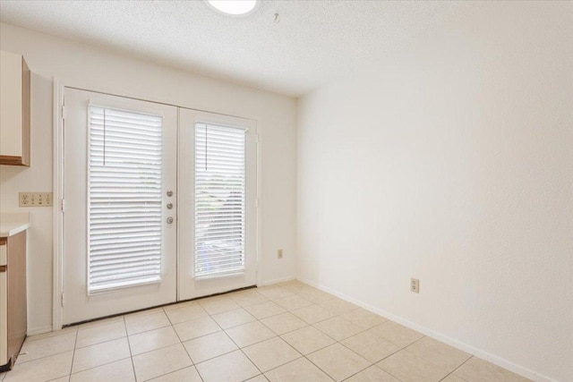 1015 E Yager Ln Unit 157, Austin, TX 78753 - unfurnished dining area with french doors, a textured ceiling, and baseboards