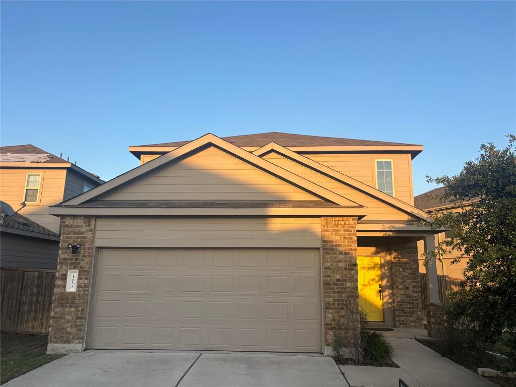 117 Open Sky Way Unit 4D, Jarrell, TX 76537 - view of front of property with brick siding, concrete driveway, a garage, and fence