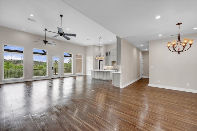 unfurnished living room featuring baseboards, dark wood-type flooring, visible vents, and recessed lighting