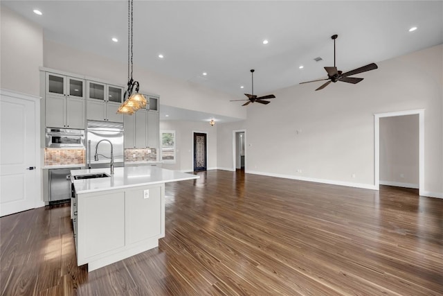kitchen featuring an island with sink, open floor plan, light countertops, and recessed lighting