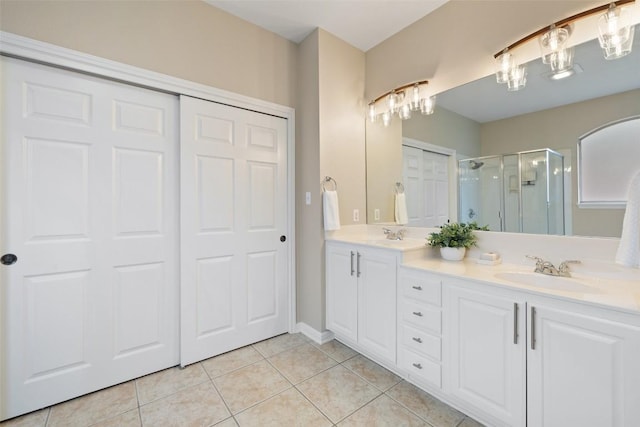 full bathroom with double vanity, tile patterned flooring, a shower stall, and a sink