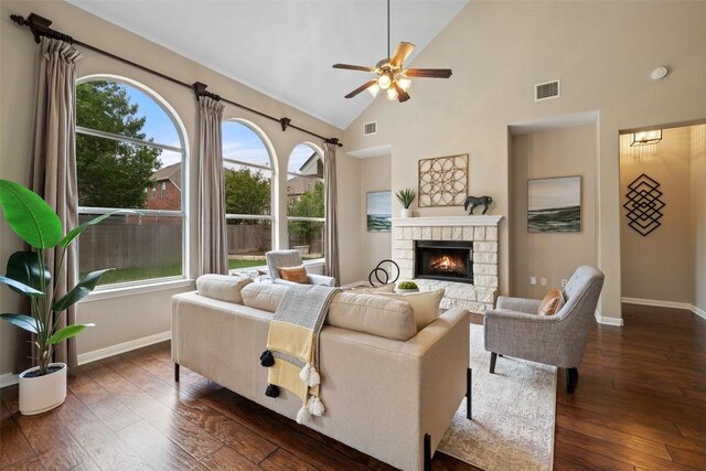 living room featuring ceiling fan, plenty of natural light, a stone fireplace, and visible vents
