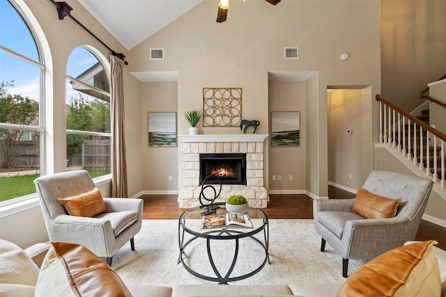 living room featuring ceiling fan, high vaulted ceiling, and visible vents