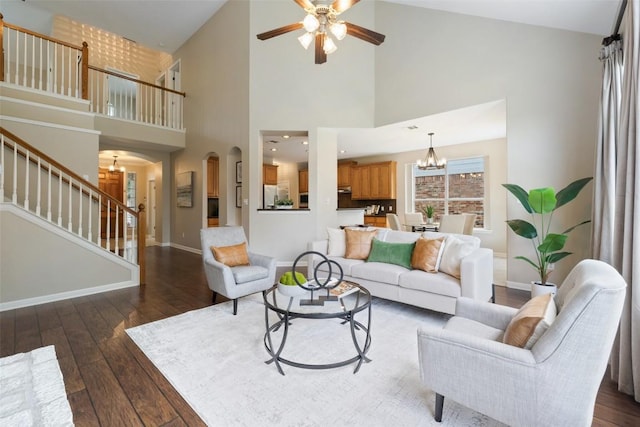 11121 Sandstone Trl, Austin, TX 78750 - living area with arched walkways, dark wood finished floors, ceiling fan, stairway, and high vaulted ceiling