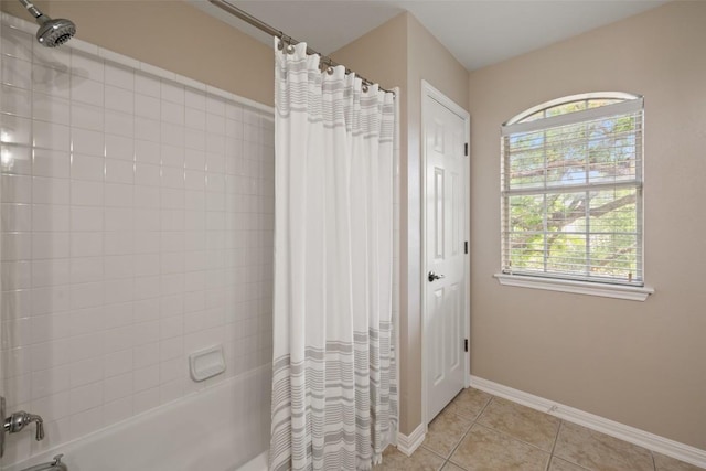 bathroom featuring tile patterned floors, baseboards, plenty of natural light, and shower / bath combination with curtain