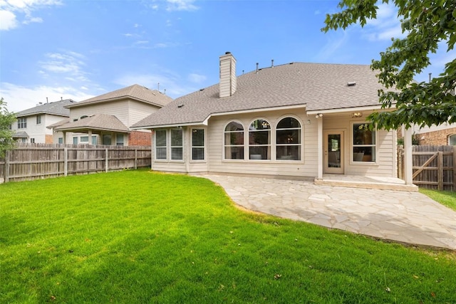 back of property featuring a patio, a fenced backyard, a chimney, a lawn, and a shingled roof