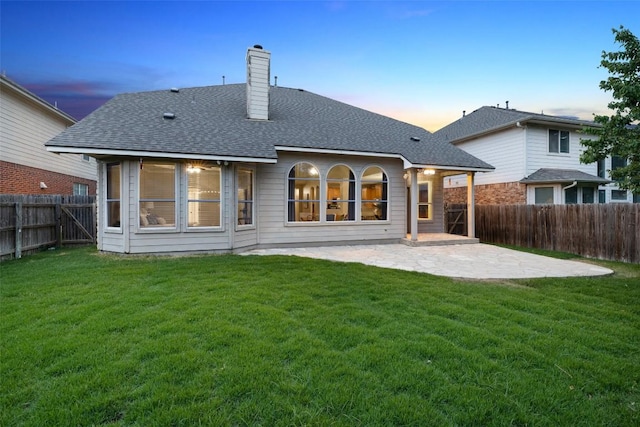 11121 Sandstone Trl, Austin, TX 78750 - back of property at dusk with a patio, a chimney, a fenced backyard, and roof with shingles