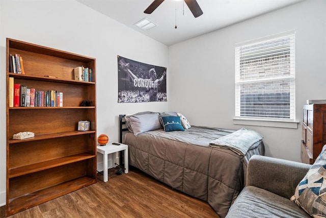 bedroom featuring ceiling fan, visible vents, and wood finished floors