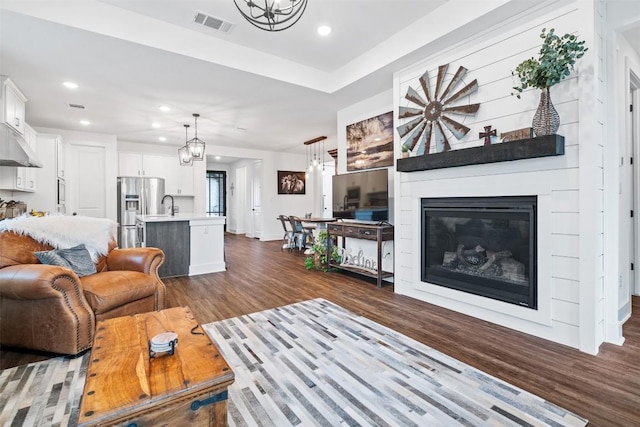 living room featuring a chandelier, dark wood-style floors, visible vents, and recessed lighting