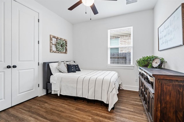 bedroom with dark wood-style flooring, baseboards, ceiling fan, and visible vents