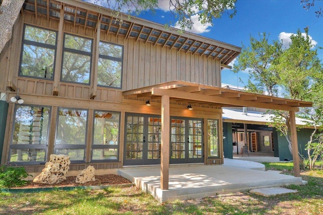 rear view of property with board and batten siding and a patio area