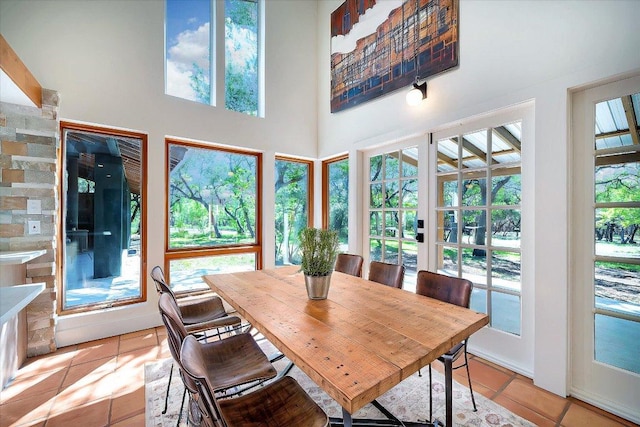 dining area featuring light tile patterned floors and a towering ceiling