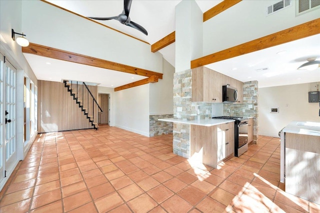 kitchen with stainless steel microwave, ceiling fan, backsplash, beamed ceiling, and range with gas cooktop