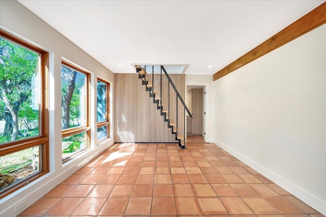 interior space featuring light tile patterned floors, stairs, and baseboards