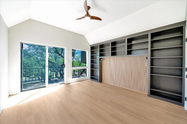 unfurnished living room with wood finished floors, ceiling fan, built in features, and vaulted ceiling
