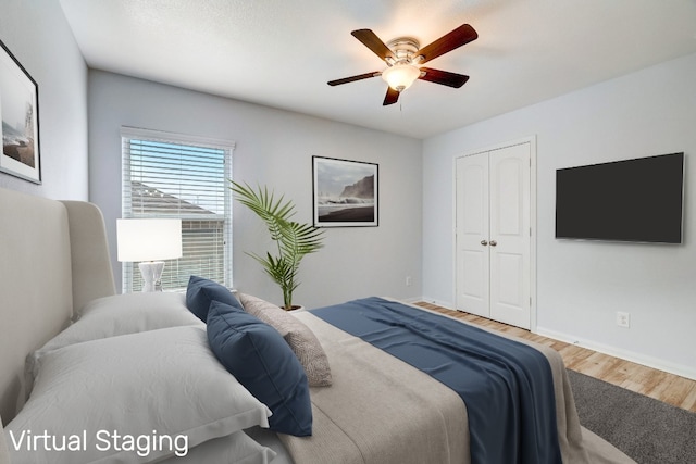 bedroom featuring a closet, wood finished floors, baseboards, and ceiling fan