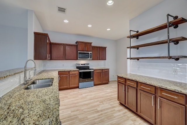 kitchen with backsplash, stainless steel appliances, open shelves, and a sink