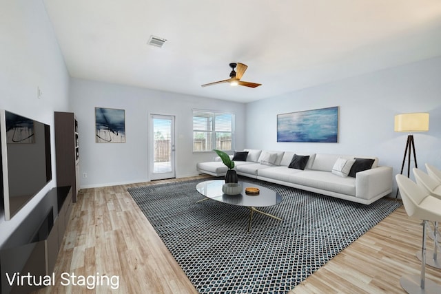 living room featuring light wood-style floors, visible vents, baseboards, and ceiling fan