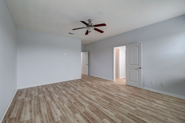 empty room featuring light wood finished floors, visible vents, baseboards, and ceiling fan