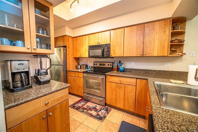 kitchen with glass insert cabinets, light tile patterned flooring, a sink, open shelves, and appliances with stainless steel finishes