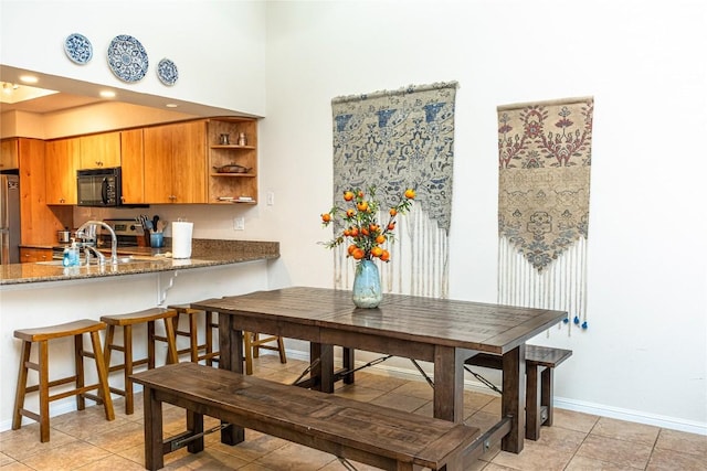 dining room featuring baseboards and light tile patterned floors
