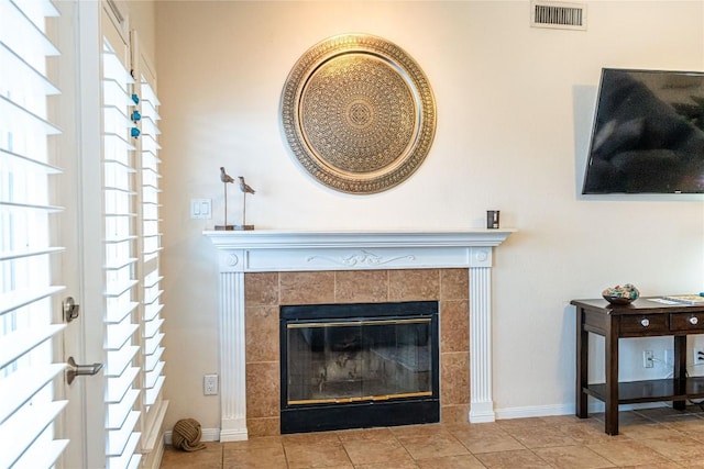 room details with a tile fireplace, visible vents, and baseboards