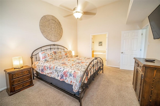 bedroom with ceiling fan, light carpet, connected bathroom, and baseboards