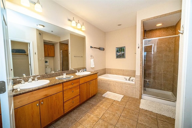 bathroom with a sink, a shower stall, and tile patterned floors