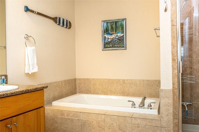 full bathroom featuring vanity, a garden tub, and a tile shower