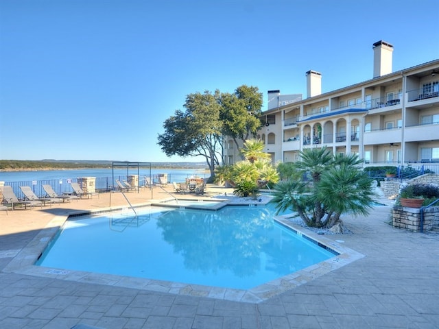 pool featuring a patio and a water view