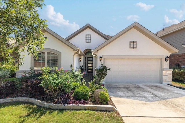 view of front facade featuring an attached garage, stucco siding, and driveway