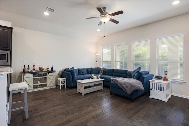 living room featuring dark wood-type flooring, visible vents, recessed lighting, vaulted ceiling, and a ceiling fan