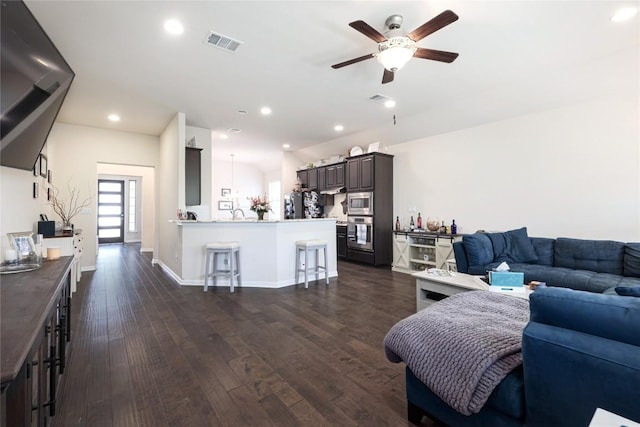living room featuring visible vents, recessed lighting, ceiling fan, dark wood-style floors, and baseboards