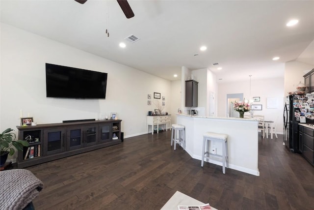 living room featuring visible vents, recessed lighting, ceiling fan, dark wood-style flooring, and baseboards