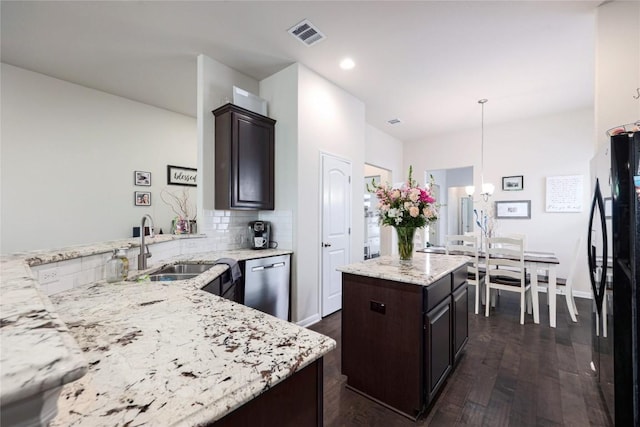 kitchen with freestanding refrigerator, stainless steel dishwasher, dark brown cabinets, and an inviting chandelier