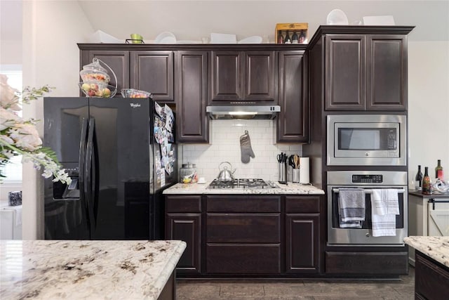kitchen with under cabinet range hood, dark brown cabinetry, stainless steel appliances, and backsplash