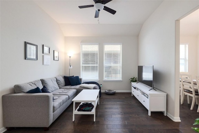 living area with a wealth of natural light, vaulted ceiling, ceiling fan, and dark wood-style floors