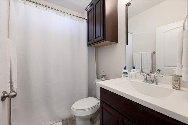 bathroom with toilet, curtained shower, and vanity