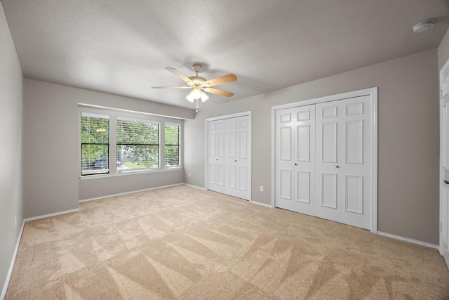 13105 Lubbock Ln, Austin, TX 78729 - unfurnished bedroom with multiple closets, carpet floors, and a ceiling fan